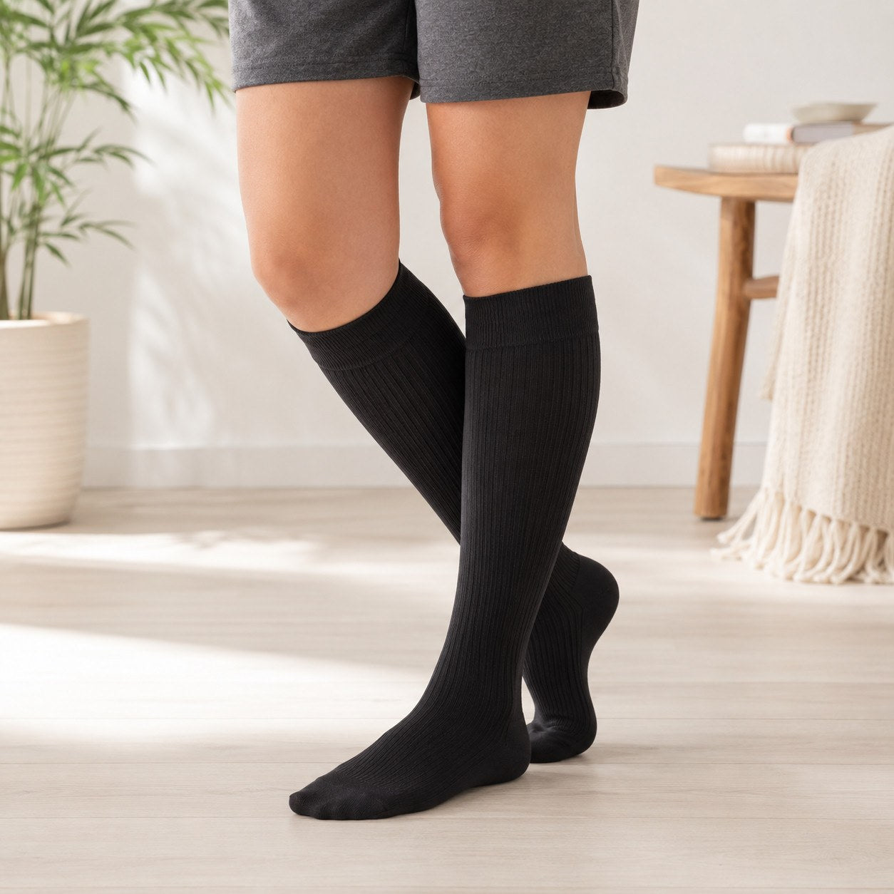 Pregnant woman wearing the black Relievoo Pregnancy Compression Socks for swelling and tired-leg relief