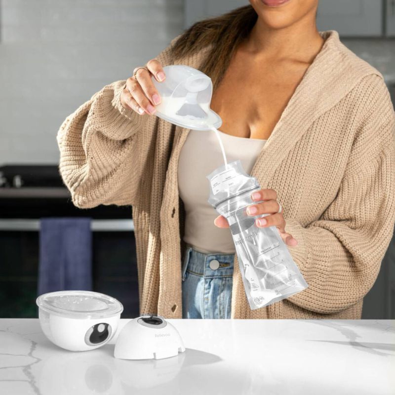 Mum using Relievoo wearable breast pump while holding baby